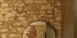 Exposed limestone brick wall in bathroom at Coastal Alchemy by The Stylesmiths
