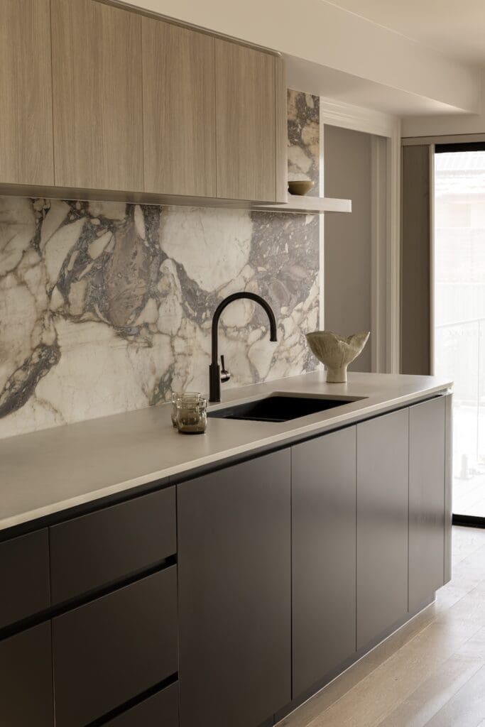 Kitchen sink with natural stone backsplash in Deakin Home