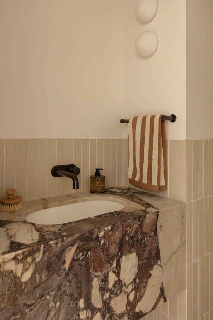 Stone vanity in powder room at Deakin Home