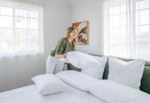 How to choose the best mattress protector: Materials, benefits and expert tips Fluffing a white pillow