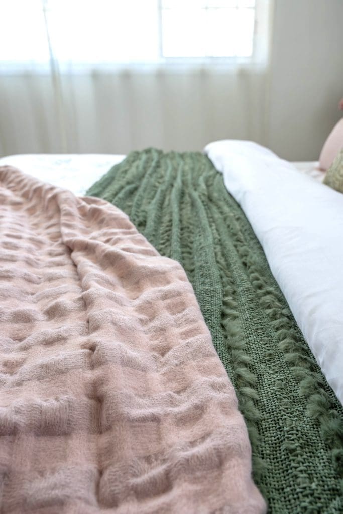 Layer throw blankets on bed